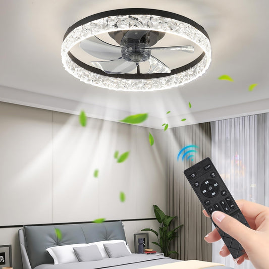 Roka z daljinskim upravljalnikom upravlja Naklikaj.si Stropna LED luč z ventilatorjem in daljinskim upravljanjem - 50 cm, črna. Krožna svetloba in pretok zraka sta vidna, v sveži spalnici z rastlinami in velikimi okni se vrtinčijo zeleni listi.